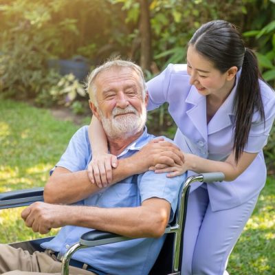 happy-nurse-holding-elderly-man-hand-wheelchair-garden-nursing-home_554837-197